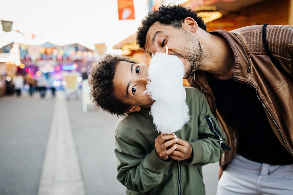 Vater und Sohn beim Naschen von Zuckerwatte