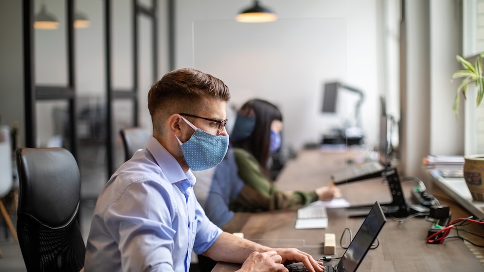 Menschen arbeiten im Büro an ihren Laptops