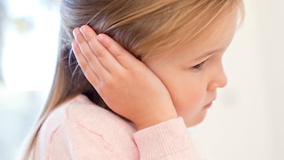 Mittelohrentzündung: Ein Mädchen hält sich das Ohr vor Schmerzen