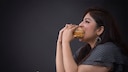 Eine Frau beisst in einen Burger