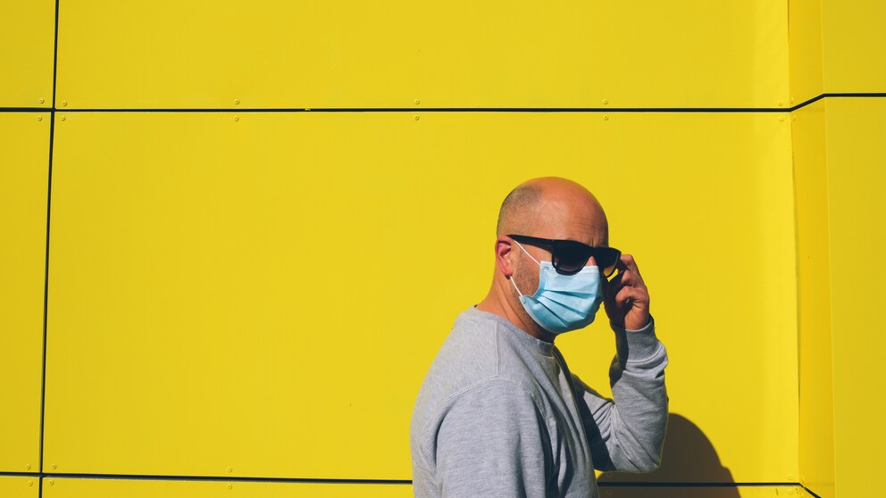 Mann mit Mundschutz in der Sonne