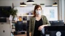 Eine Frau in einem Büro trägt eine Alltagsmaske