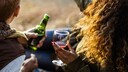 Frau und Mann trinken Rotwein oder Bier – was ist gesünder?