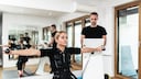 Eine Frau wird beim EMS-Training von einem Trainer beobachtet