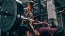 Zwei M&auml;nner beim Bankdrucken im Gym