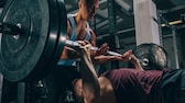 Zwei Männer beim Bankdrucken im Gym