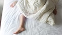 Zucken beim Einschlafen: Frau liegt im Bett