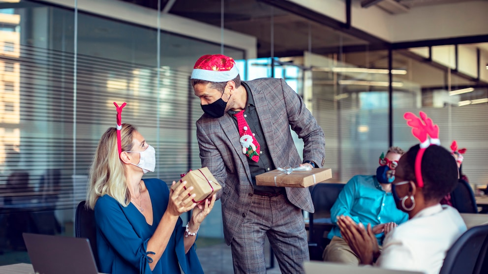 Geschenke werden bei einer Weihnachtsfeier im Büro überreicht