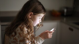 Kind blickt auf Smartphone