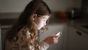 Kind blickt auf Smartphone