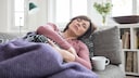 Frau schläft auf Sofa