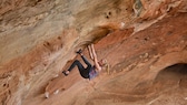 Frau klettert an rotem Felsen in Australien
