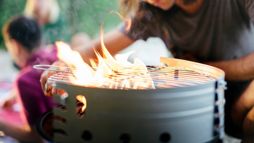 Ein Mann entfacht ein Feuer auf dem Grill