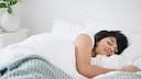 Eine Frau liegt schlafend im Bett