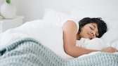 Eine Frau liegt schlafend im Bett