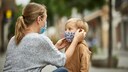 Eine Frau zieht einem Jungen eine Maske auf