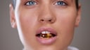 Eine Frau mit einer Supplement-Kapsel zwischen den Zähnen