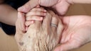 maximale Lebensdauer Mensch: Eine Babyhand, Hände eines Erwachsenen und eine Hand einer älteren Person halten sich