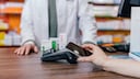 Eine Apotheken-Kundin mit Smartphone