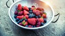Schüssel mit Erdbeeren, Himbeeren und Heidelbeeren