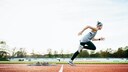Sport Erfolg Trainingsbeginn: Eine Frau sprintet über einen Sportplatz