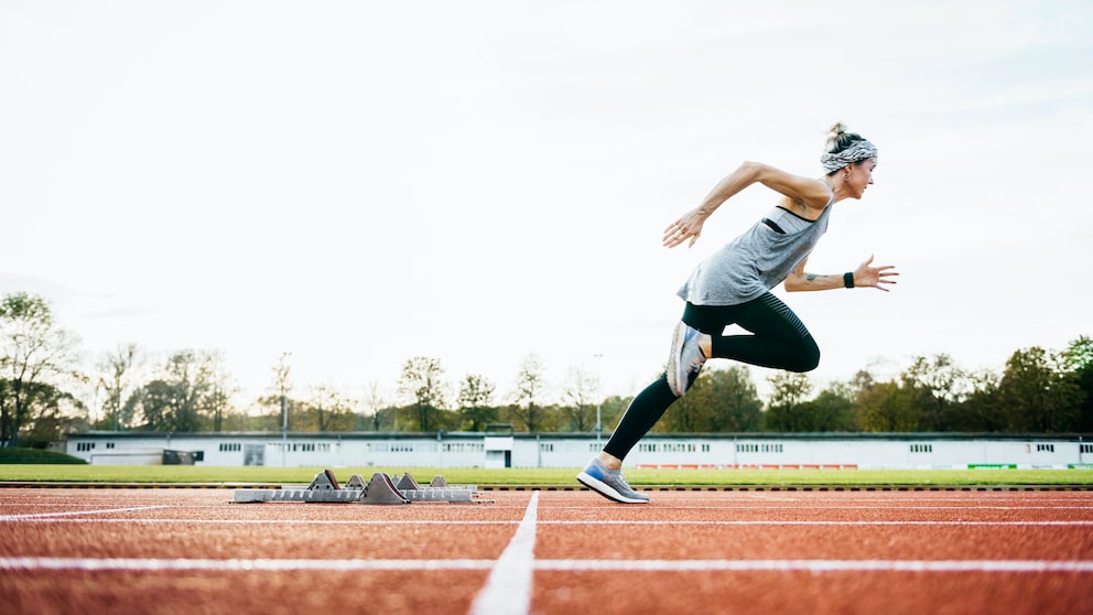 Sport Erfolg Trainingsbeginn: Eine Frau sprintet über einen Sportplatz