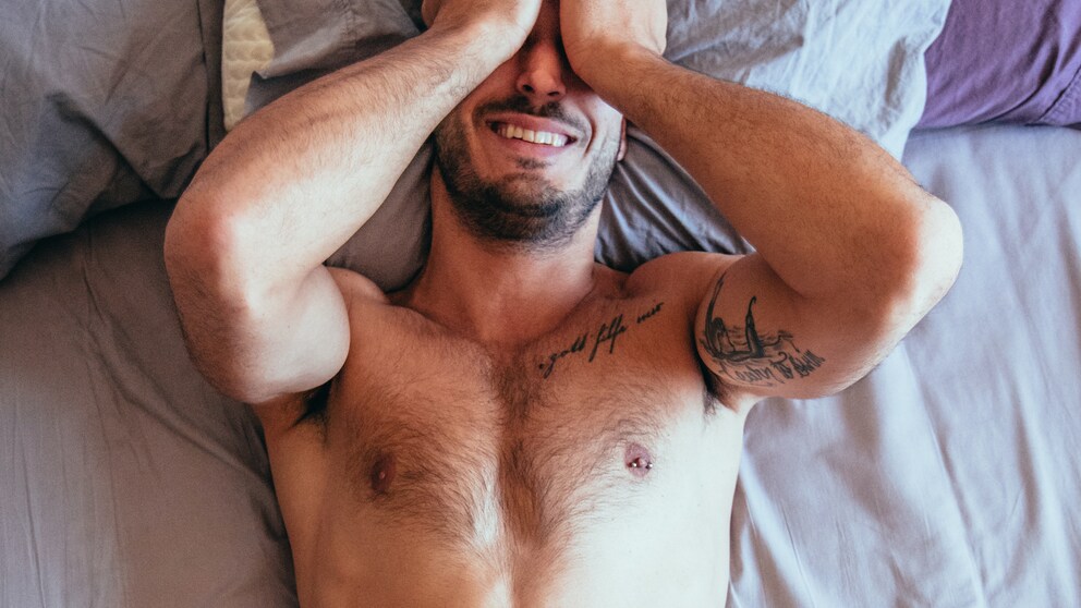 Ein Mann mit nacktem Oberkörper im Bett