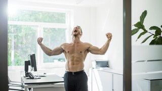 Testosteron Erfolg: Ein oberkörperfreier Mann streckt seine Arme aus und wirft mit offenem Mund den Kopf in den Nacken