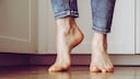 Die nackten Füße einer Frau in Jeans