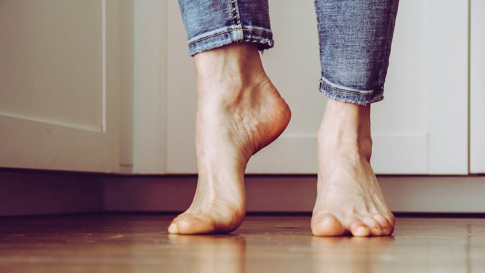 Die nackten Füße einer Frau in Jeans