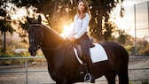 Junge Frau sitzt auf einem Pferd