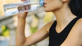 Frau trinkt aus Wasserflasche