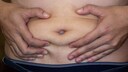 Mann zwickt sich ins Fett am Bauch