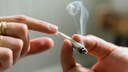 Cannabis erhöht Herzinfarktrisiko: Frauen- und Männerhand mit einem brennenden Joint