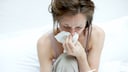 Superinfektion: Frau mit Fieberthermometer