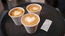 Drei Kaffeebecher mit Herzschaum