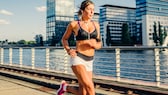 Sport und länger leben: Eine Frau joggt an einem Fluss entlang