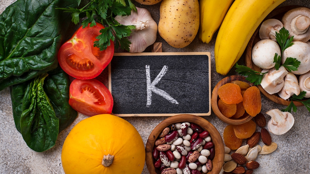 Obst und Gemüse, das Kalium enthält auf einem Tisch und in der Mitte ein „K“