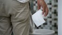 Restless-Anal-Syndrom: Mann steht mit Toilettenrolle in der Hand vor einer Toilette