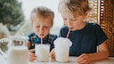Kinder trinken Milch mit Strohhalm