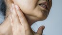 Kieferknacken: Frau mit Hand am Unterkiefer