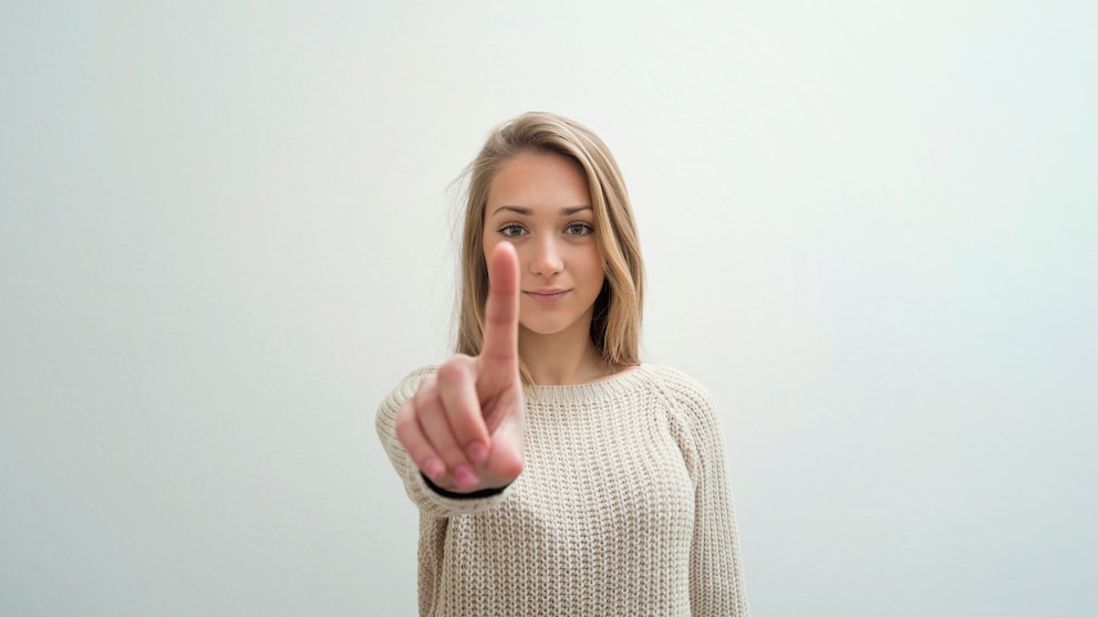 Eine junge Frau zeigt ihren Zeigefinger