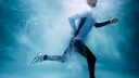 Ein Mann joggt mit voller Montur unter Wasser