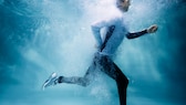 Ein Mann joggt mit voller Montur unter Wasser