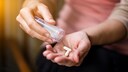 Antidepressivum Corona: Eine Frau hält zwei Pillen in der Hand