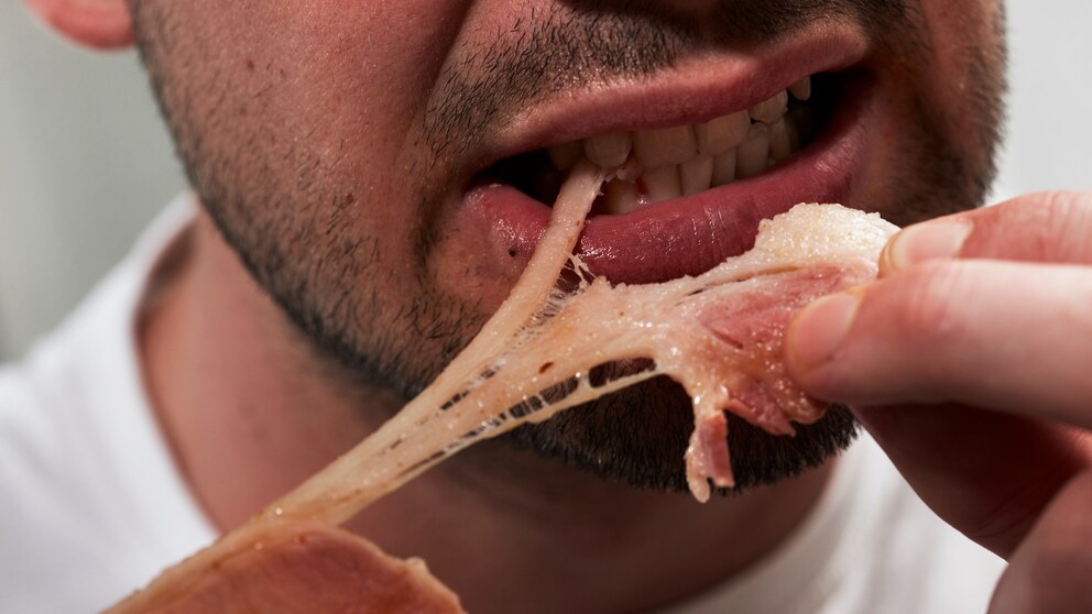 Ein Mann isst Fleisch