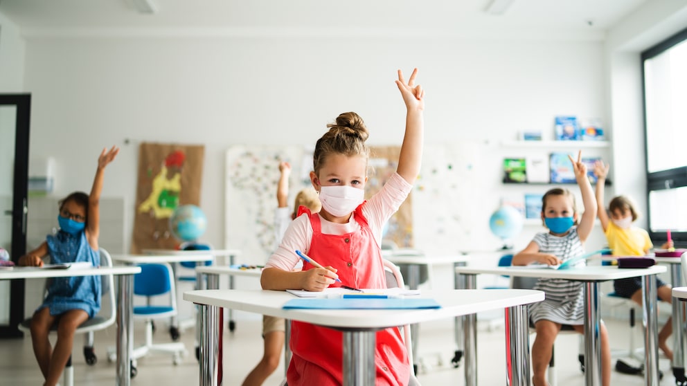 Schulkinder mit Masken in einem Klassenzimmer