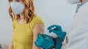 Junge Frau mit Maske wird geimpft