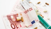 Krankenkasse Geld: Euroscheine und ein Krankenschein in Großaufnahme