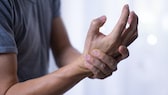 Alien-Hand-Syndrom: Mann hält sein Handgelenk